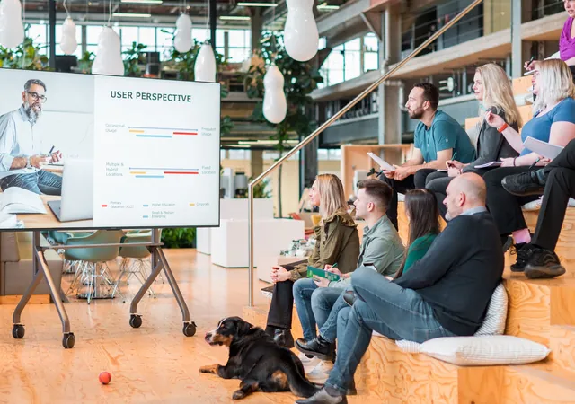 A team in a meeting area with an i3 display